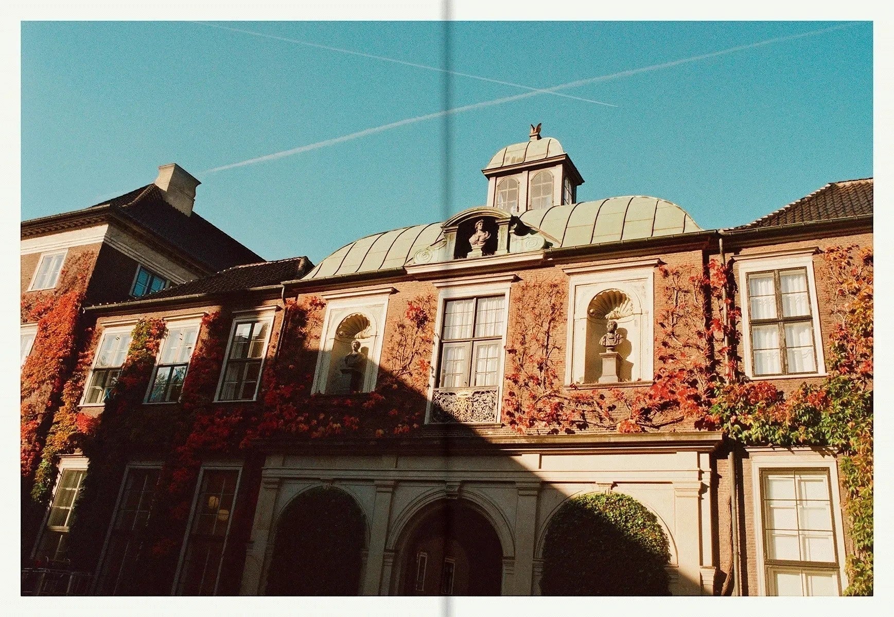 A page from the keep-collections Apollo cookbook featuring a historic brick building with autumn vines and statues.